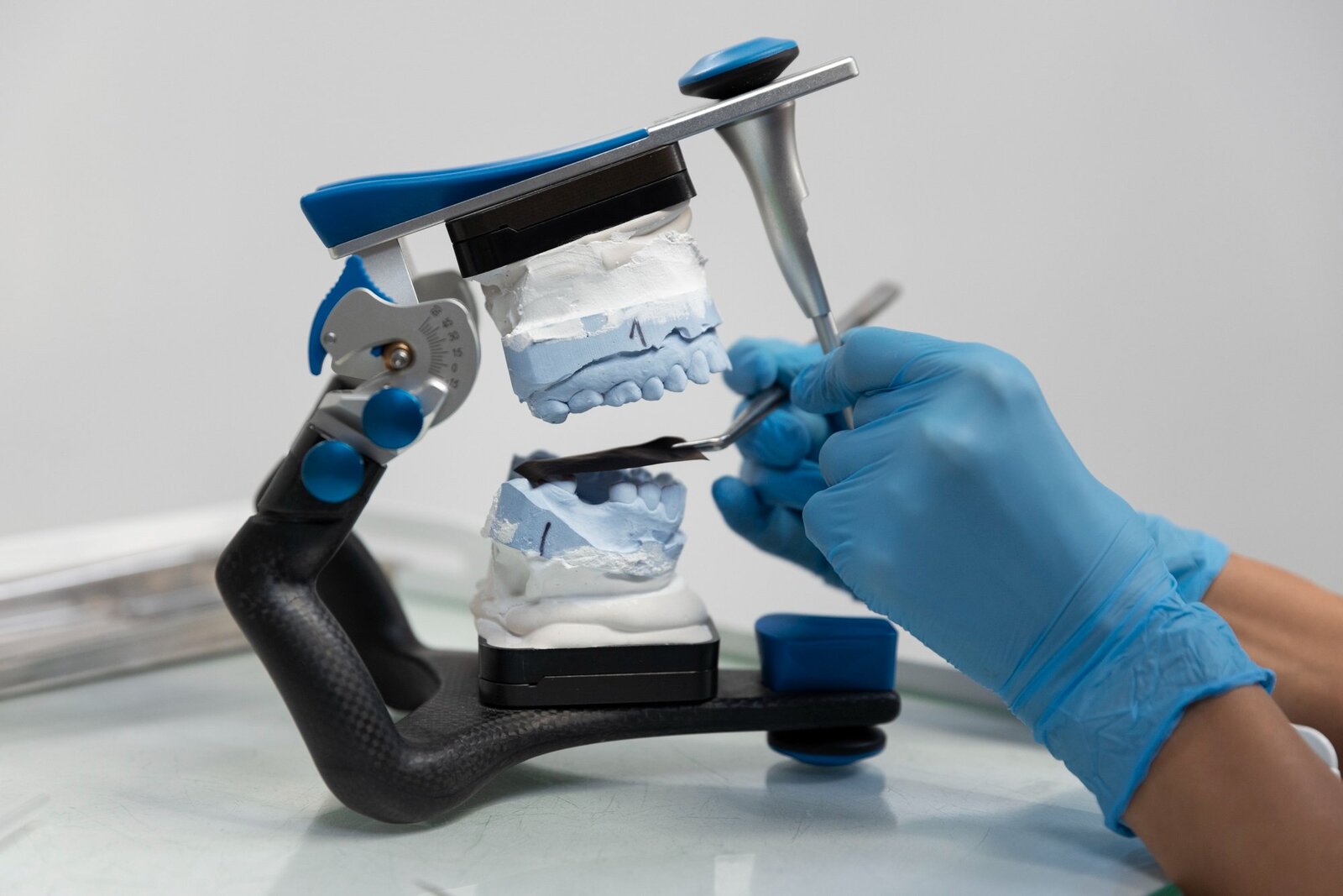 Dental technician working on stone models in articulator